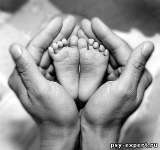 стопы младенца в руках родителя